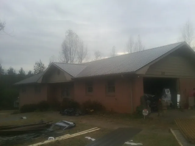 Gray metal roof on a stucco house with an attached garage in Sunnyside